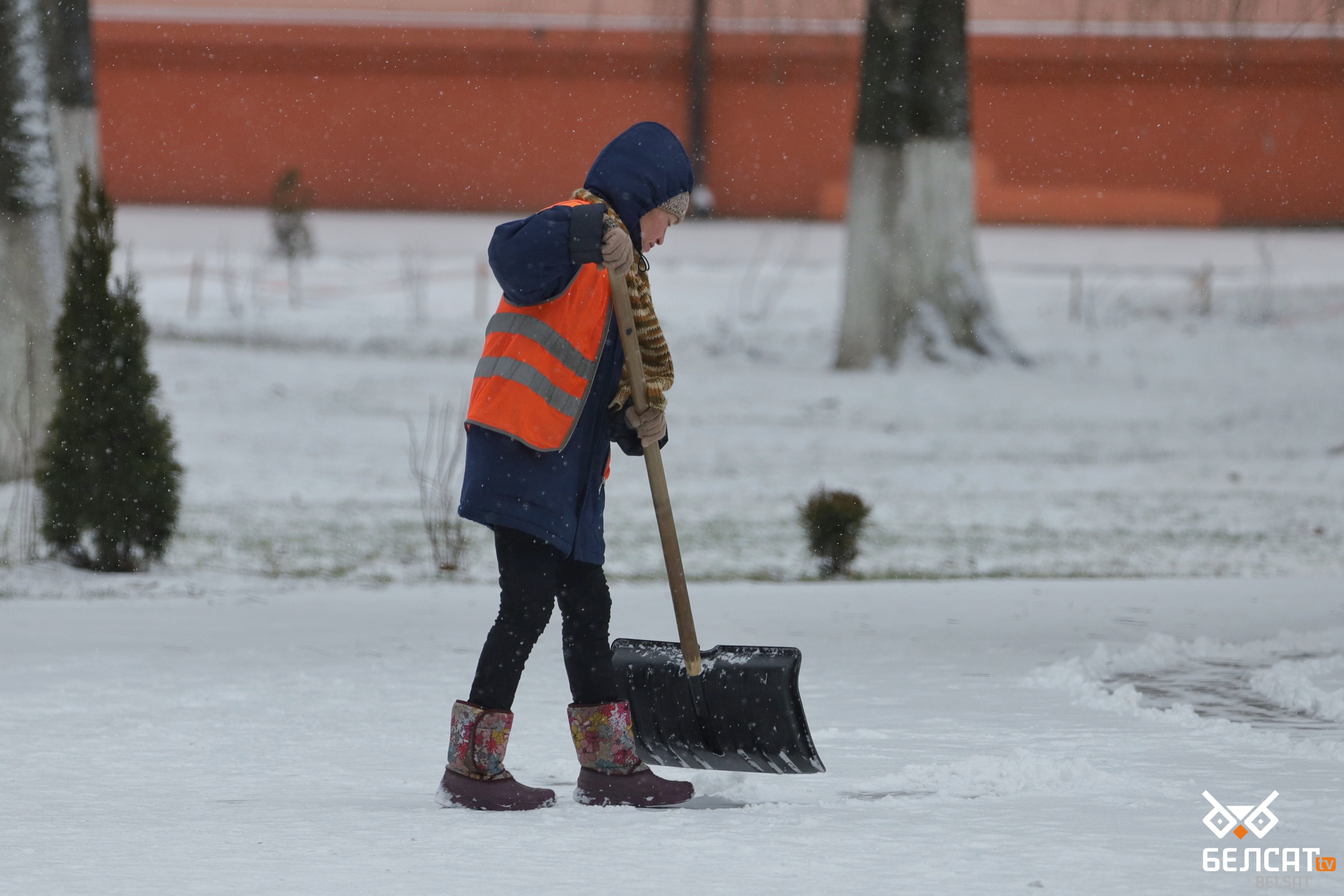 Работница жилищно-коммунального хозяйства убирает снег, морозы в Беларуси